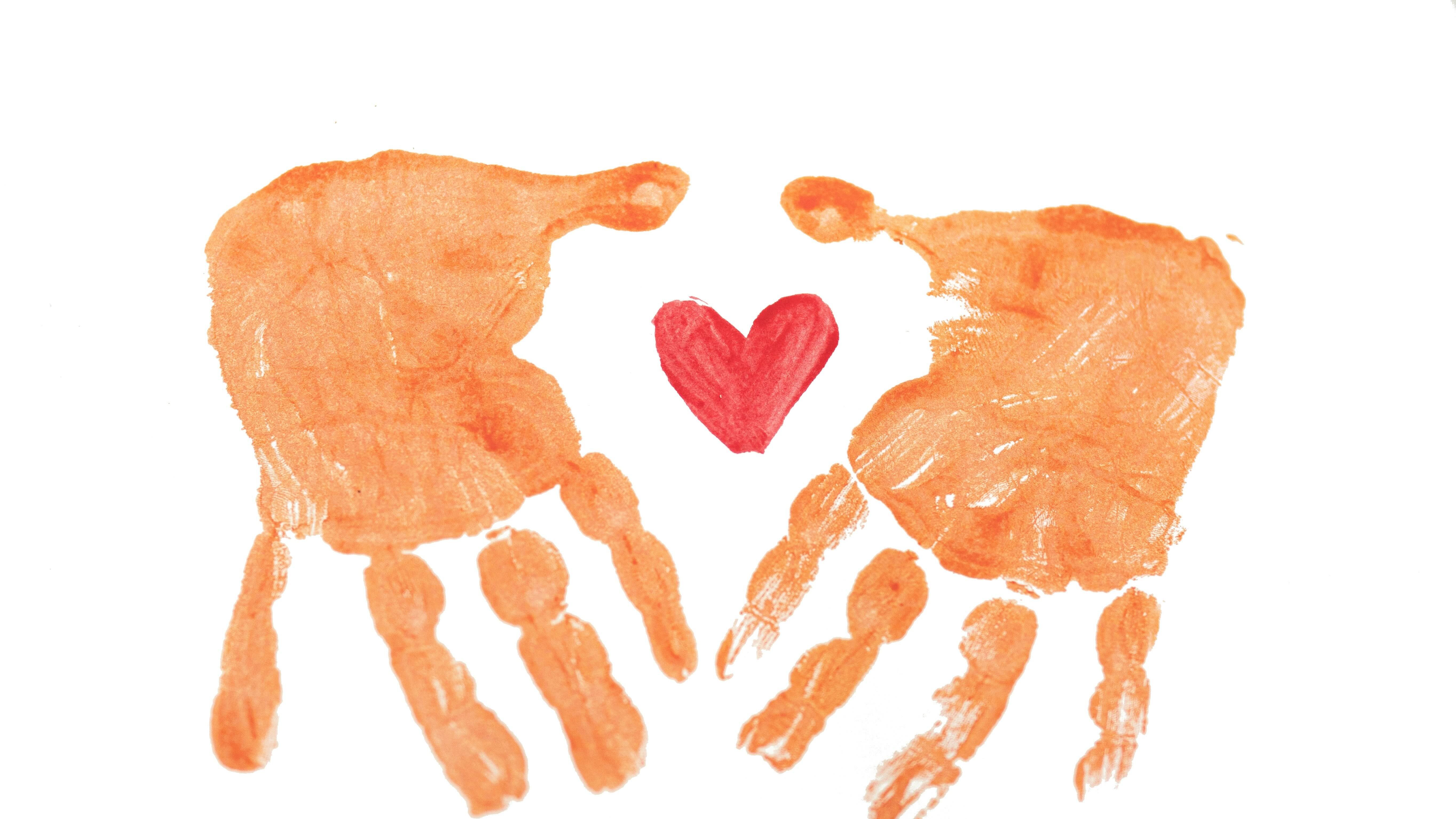 Empreintes de mains d'enfant et cœur peint – illustration symbolique de la culpabilité parentale mêlée d'amour et de tendresse.
