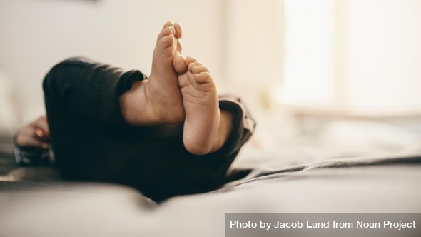 Petits pieds de nourrisson allongé paisiblement – symbole d'un sommeil doux et serein, respectueux des besoins de bébé