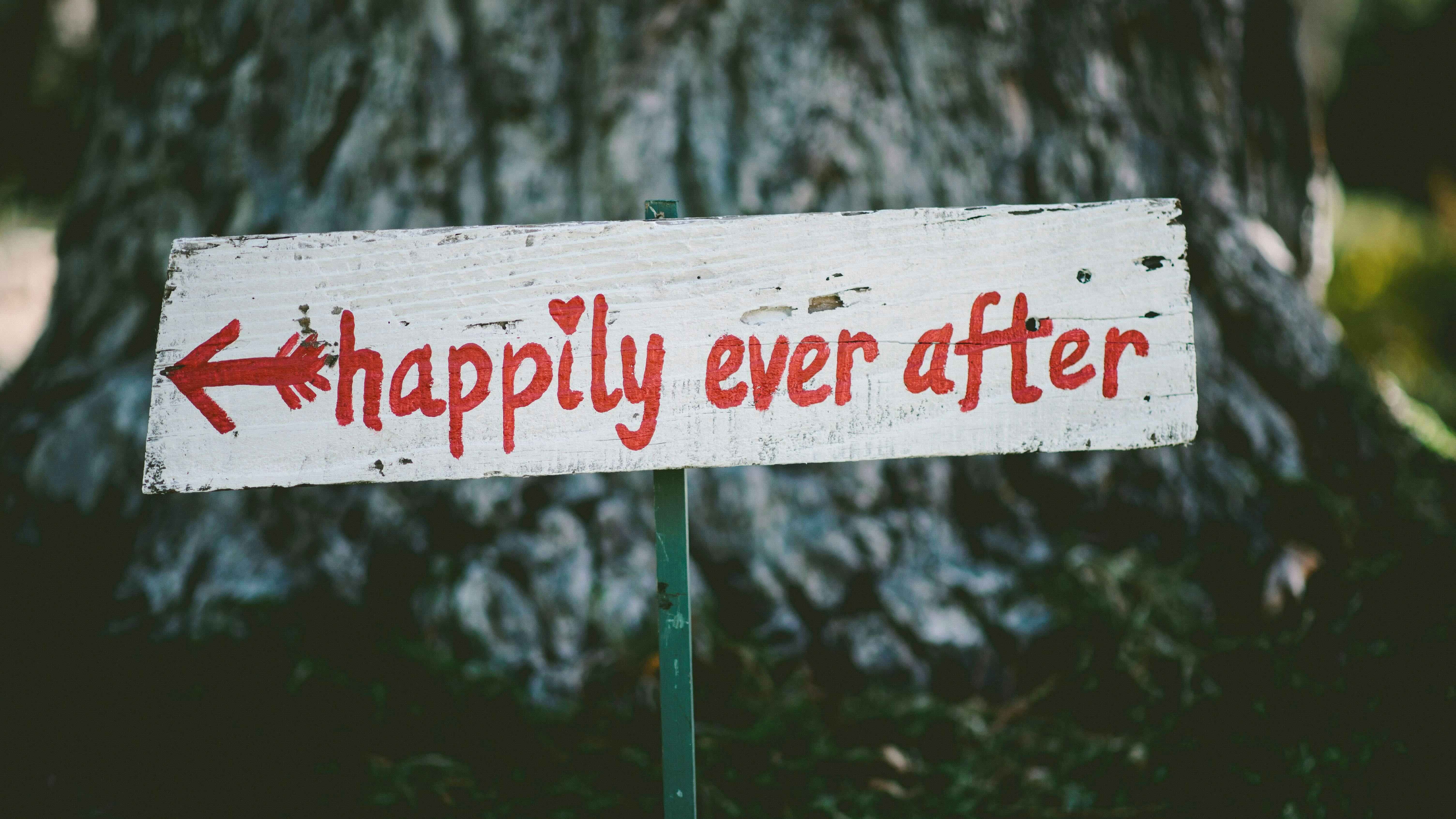 Panneau blanc peint en rouge avec message ‘happily ever after' en forêt, symbole d'un accompagnement sommeil réussi comme celui de Martin, papa d'Otis.