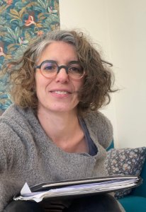 Lucie Perrin en consultation, prenant des notes avec sérieux et douceur dans son carnet de suivi du sommeil