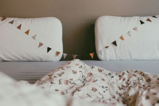 Lit deux places avec lumière du jour tamisée et guirlande Fagnon, chambre cosy de parents dans le Tarn, symbole d'un sommeil retrouvé pour toute la famille.